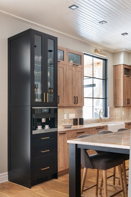 A kitchen with black cabinets and wooden cabinets