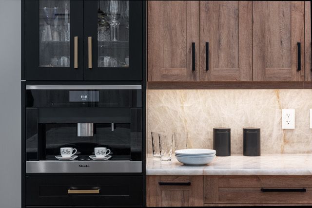 A kitchen with wooden cabinets , stainless steel appliances , and a coffee maker.