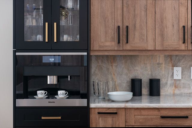 A kitchen with wooden cabinets , stainless steel appliances , and a coffee maker.