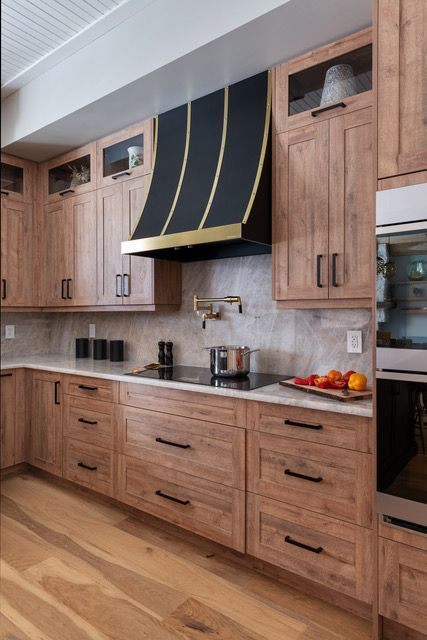 A kitchen with wooden cabinets and a black hood