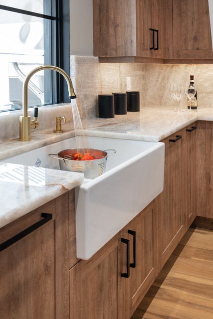 A kitchen sink with a pot of food in it and a faucet.