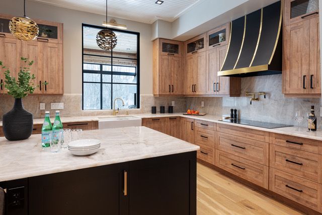 A kitchen with wooden cabinets , granite counter tops , and a large island.