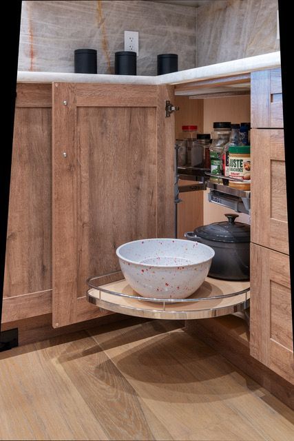 A bowl is sitting on top of a wooden shelf in a kitchen.