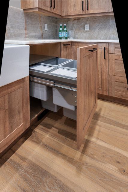 A kitchen with wooden cabinets and drawers and a sink