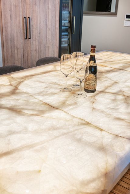 A bottle of wine and two wine glasses are on a table.