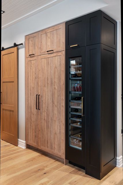 A kitchen with wooden cabinets and a black refrigerator