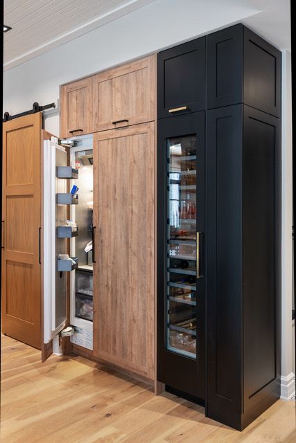 A kitchen with wooden cabinets and a black refrigerator