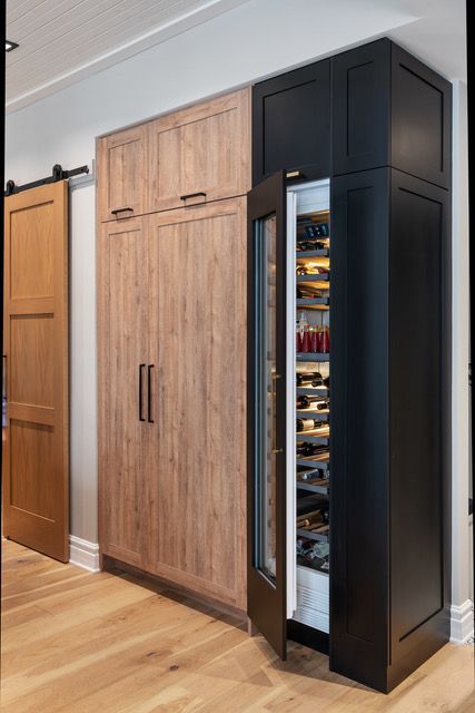 A refrigerator with a glass door is built into a cabinet in a kitchen.