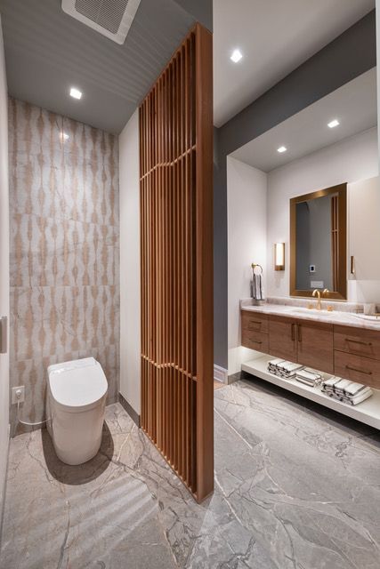 A bathroom with a toilet , sink and mirror