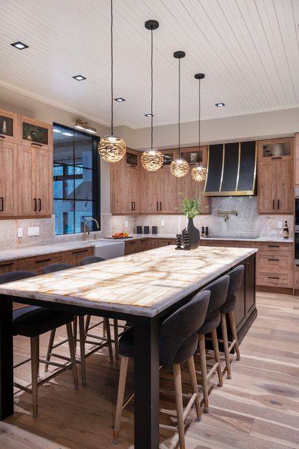 A kitchen with a large table and stools