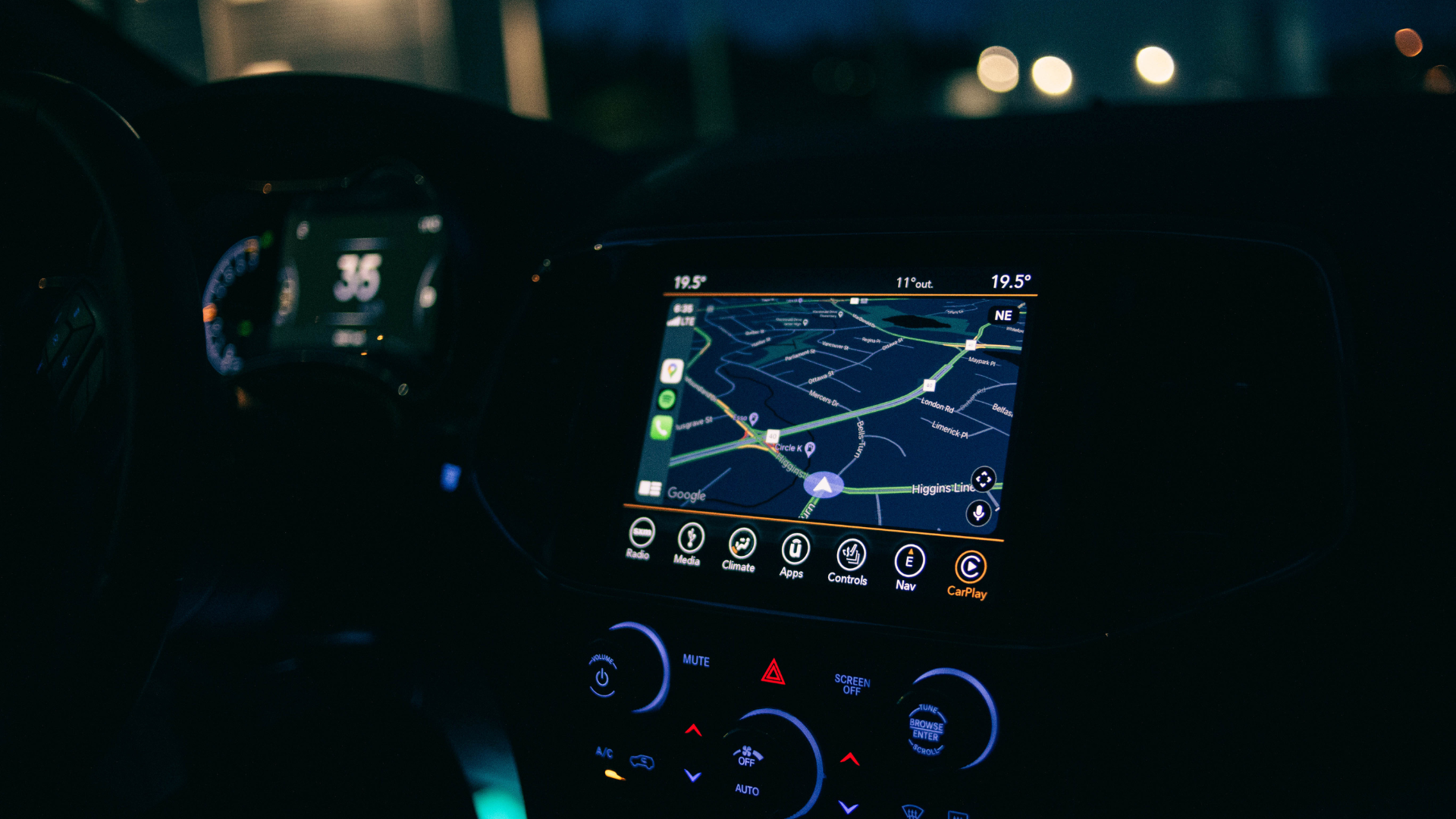 A car dashboard at night with a map on the screen.