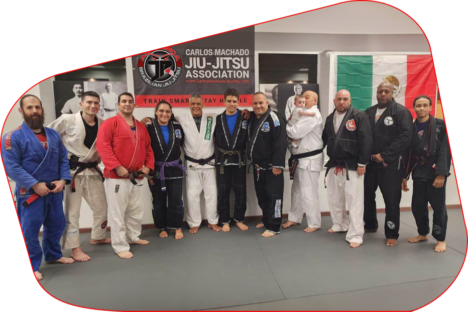 a group of people posing for a picture in front of a sign that says carlos machado jiu-jitsu association