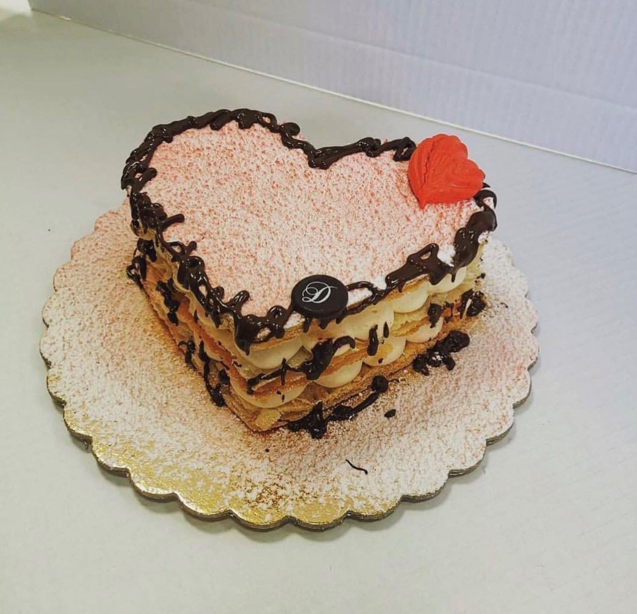 a heart shaped cake with a red heart on top