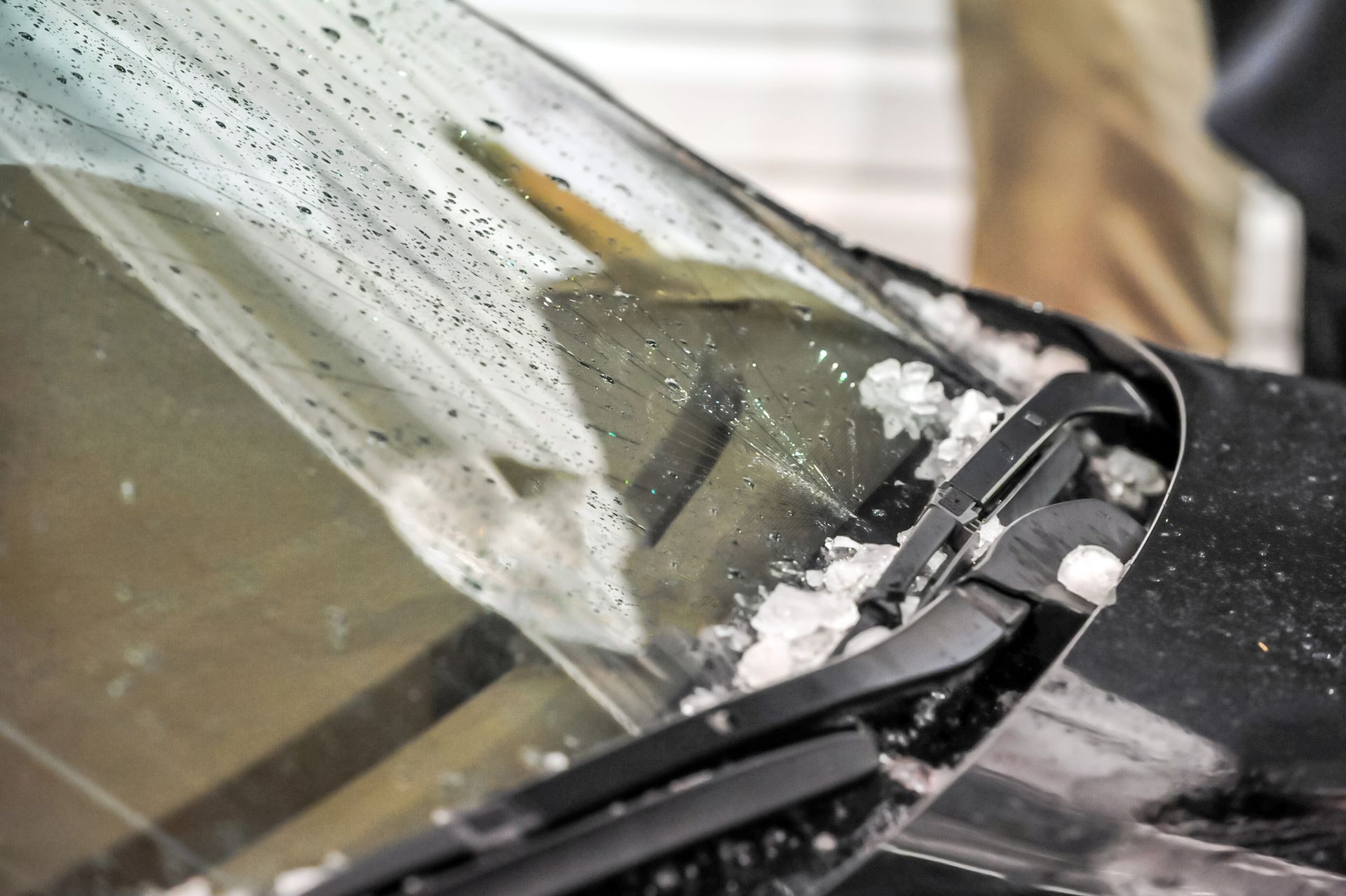 Snow and ice covering a car windshield with wiper blades.