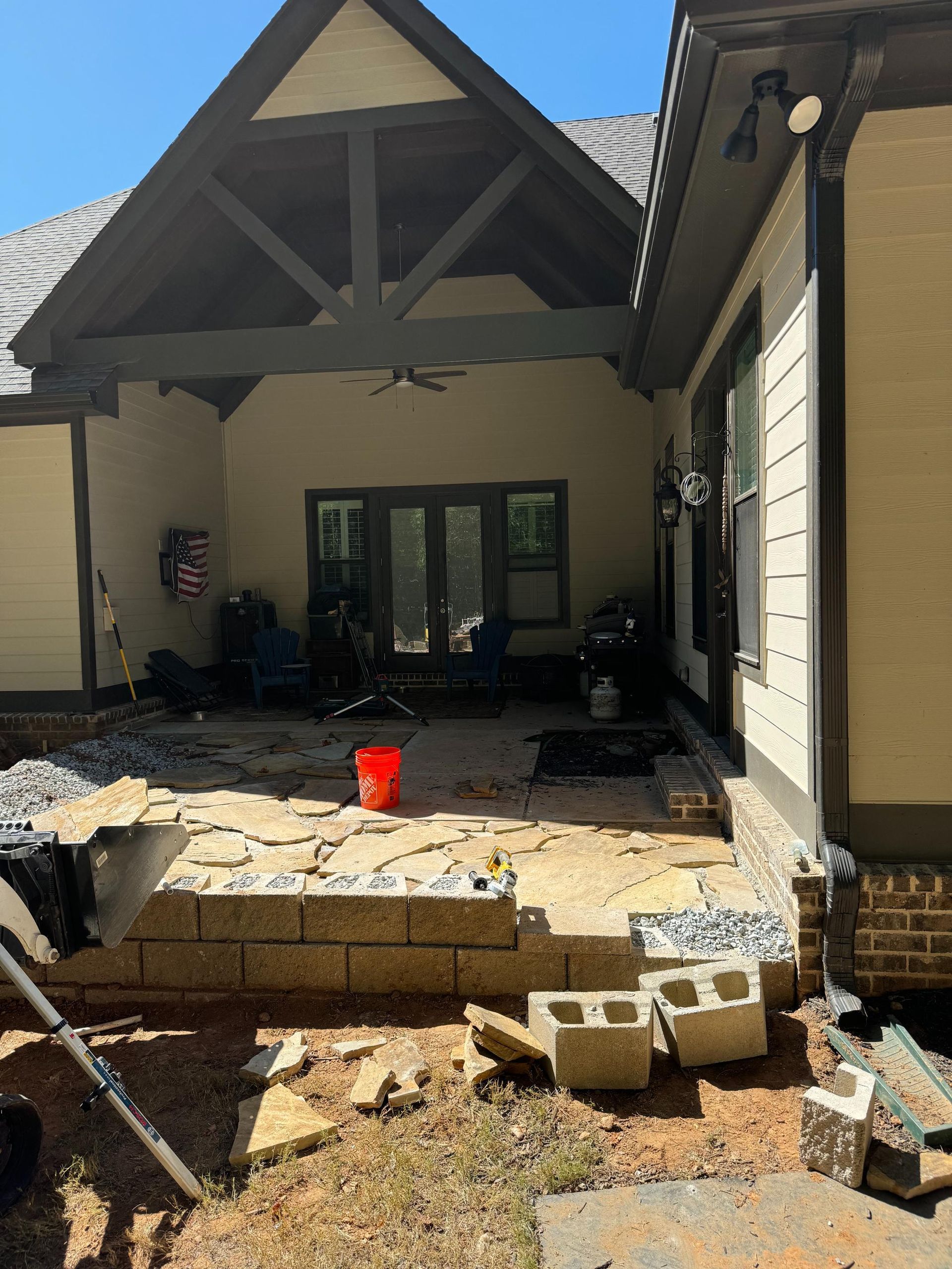A house with a patio being built in front of it