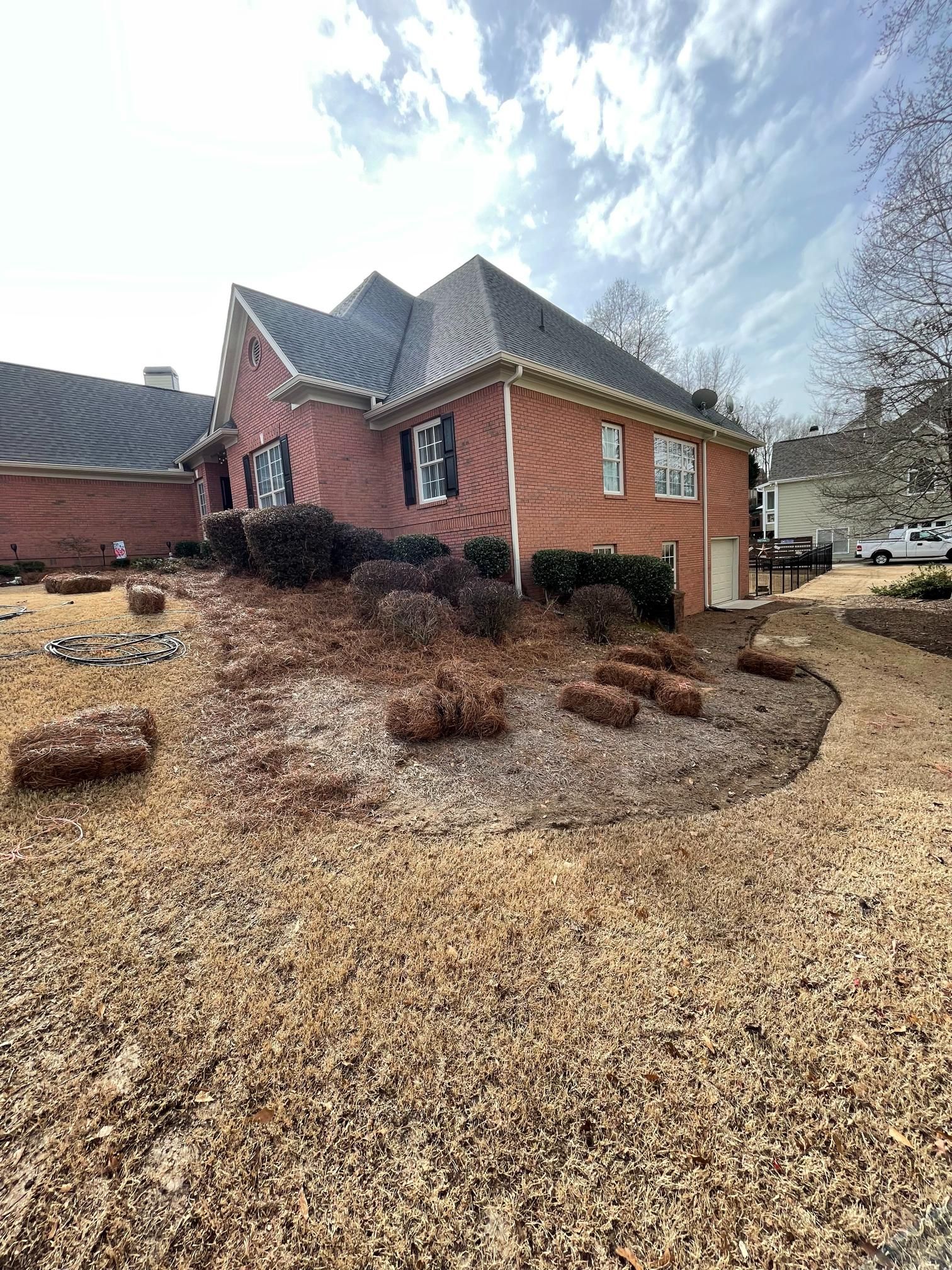 A large brick house with a lot of dirt in front of it.
