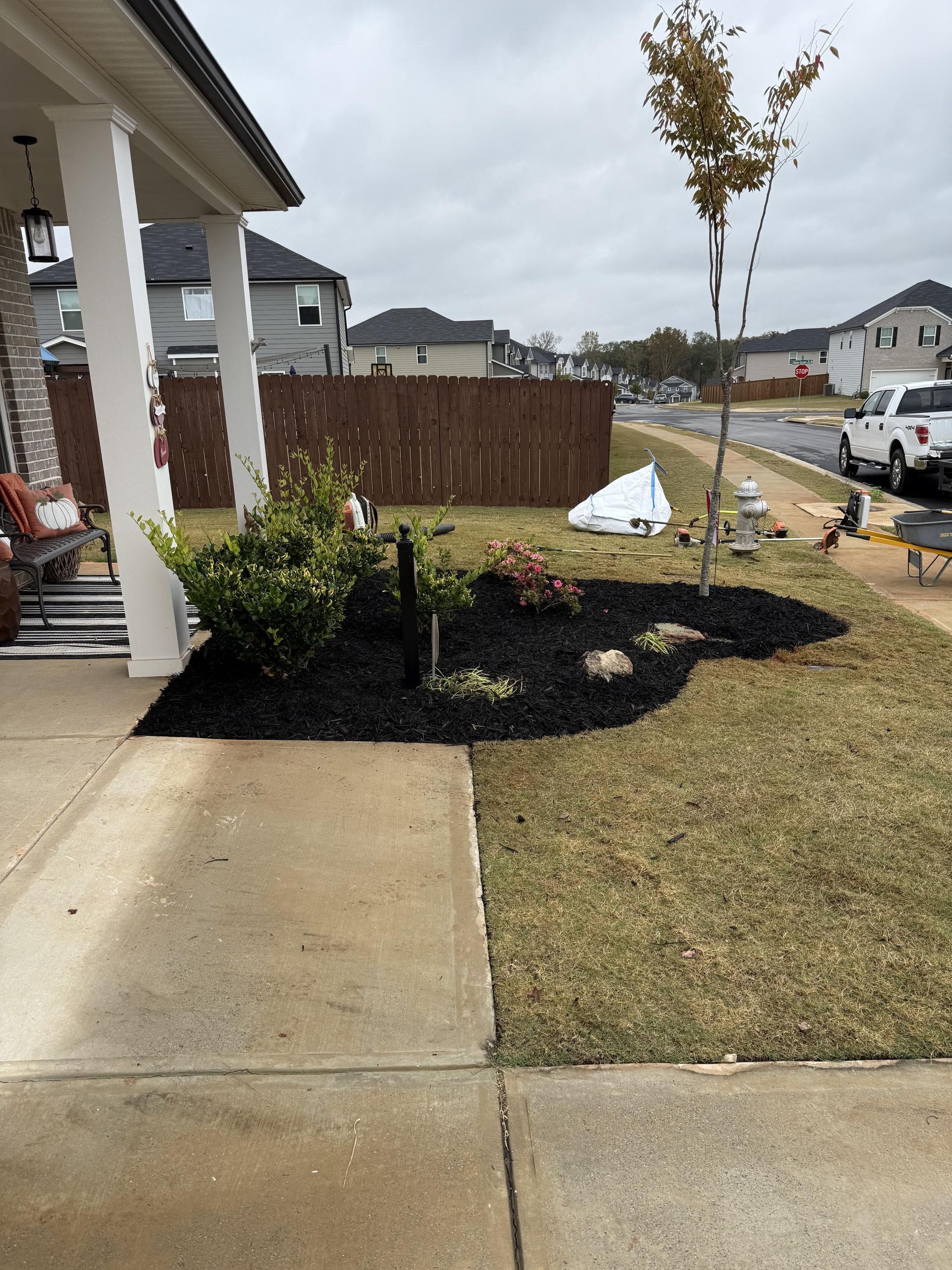 A house with a porch and a lawn in front of it.