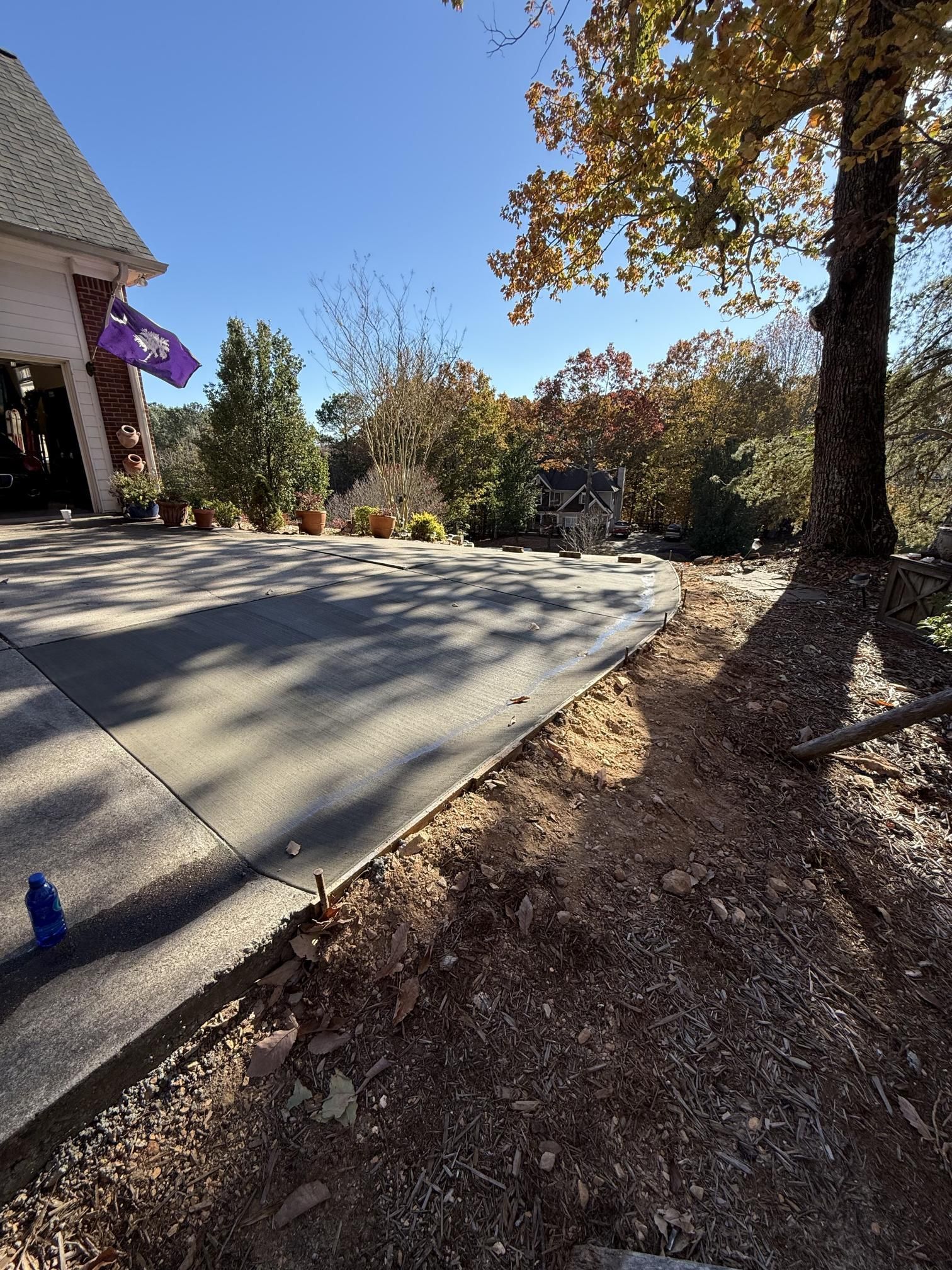 A concrete driveway is being built in front of a house.