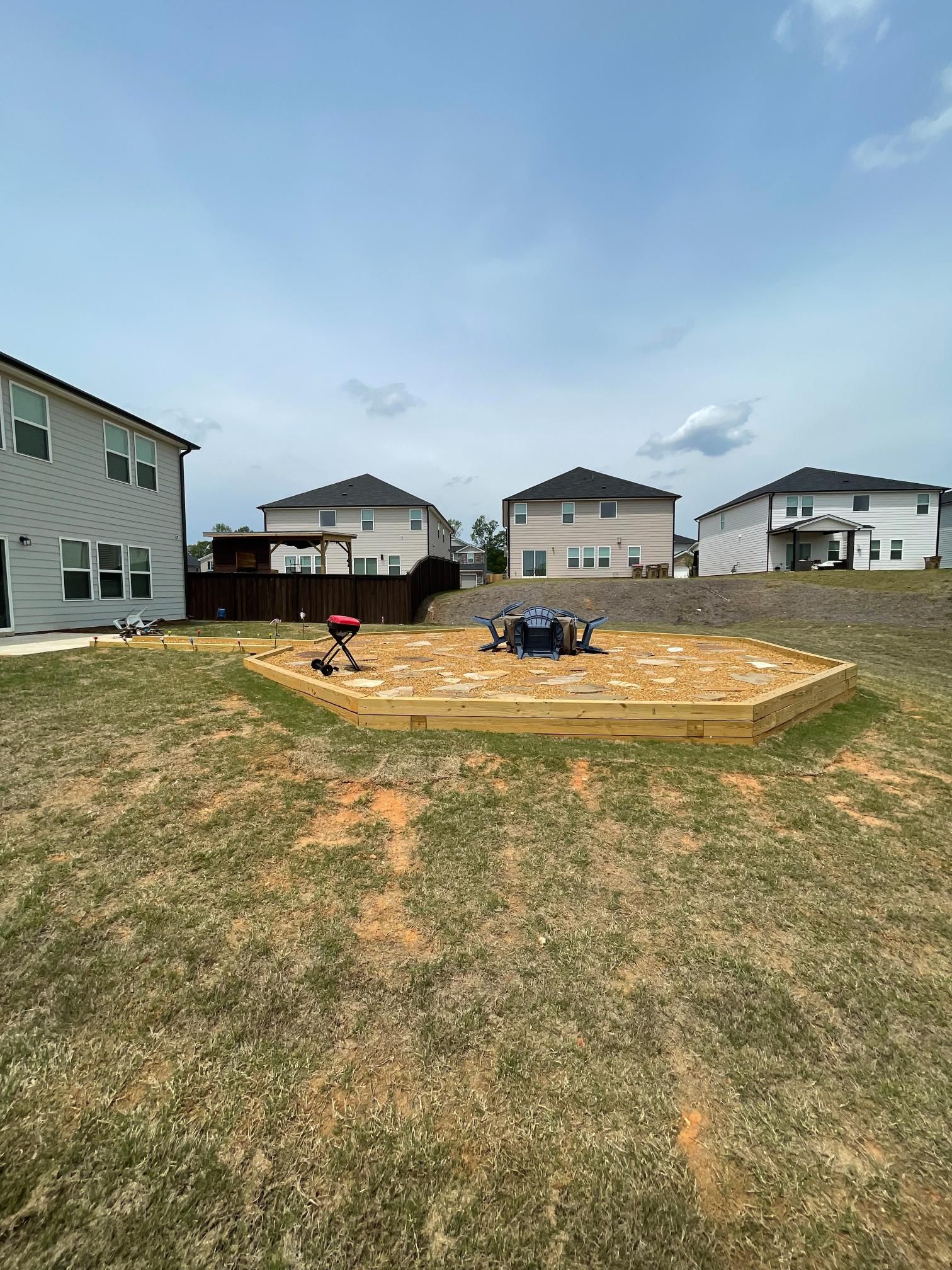 A wooden deck is being built in the backyard of a house.