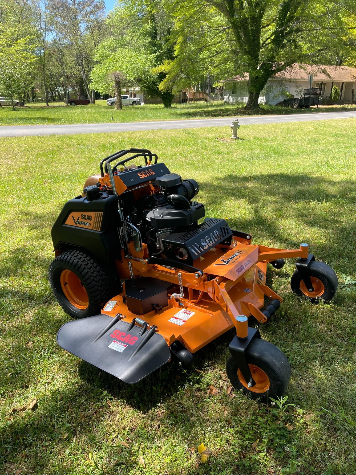 A lawn mower is sitting on top of a lush green field.