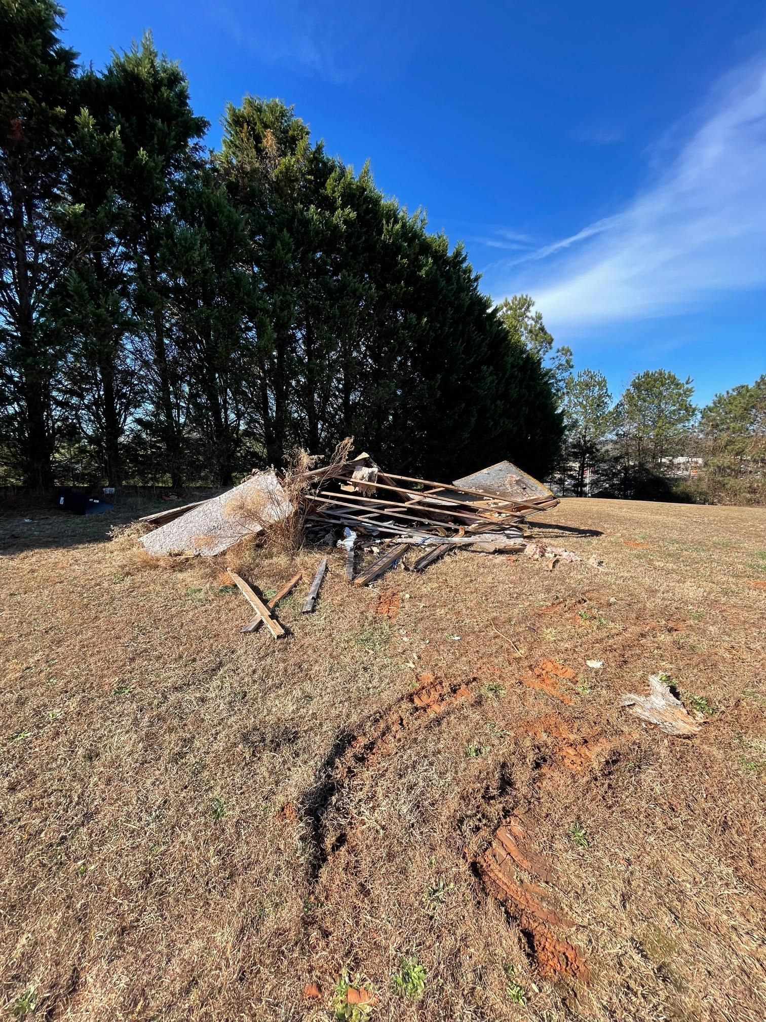 There is a pile of wood in the middle of a field.