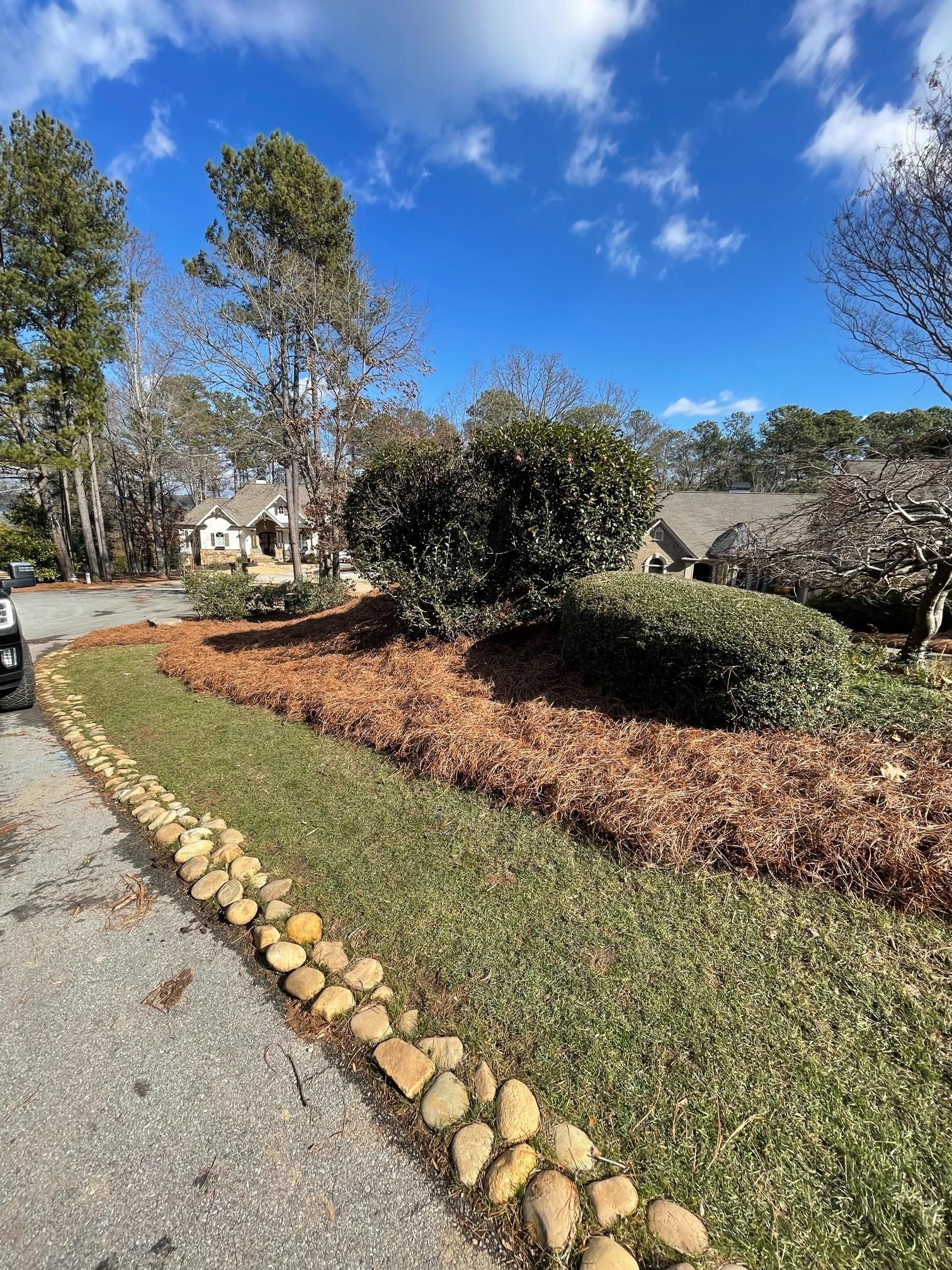 A car is parked on the side of the road in front of a house.