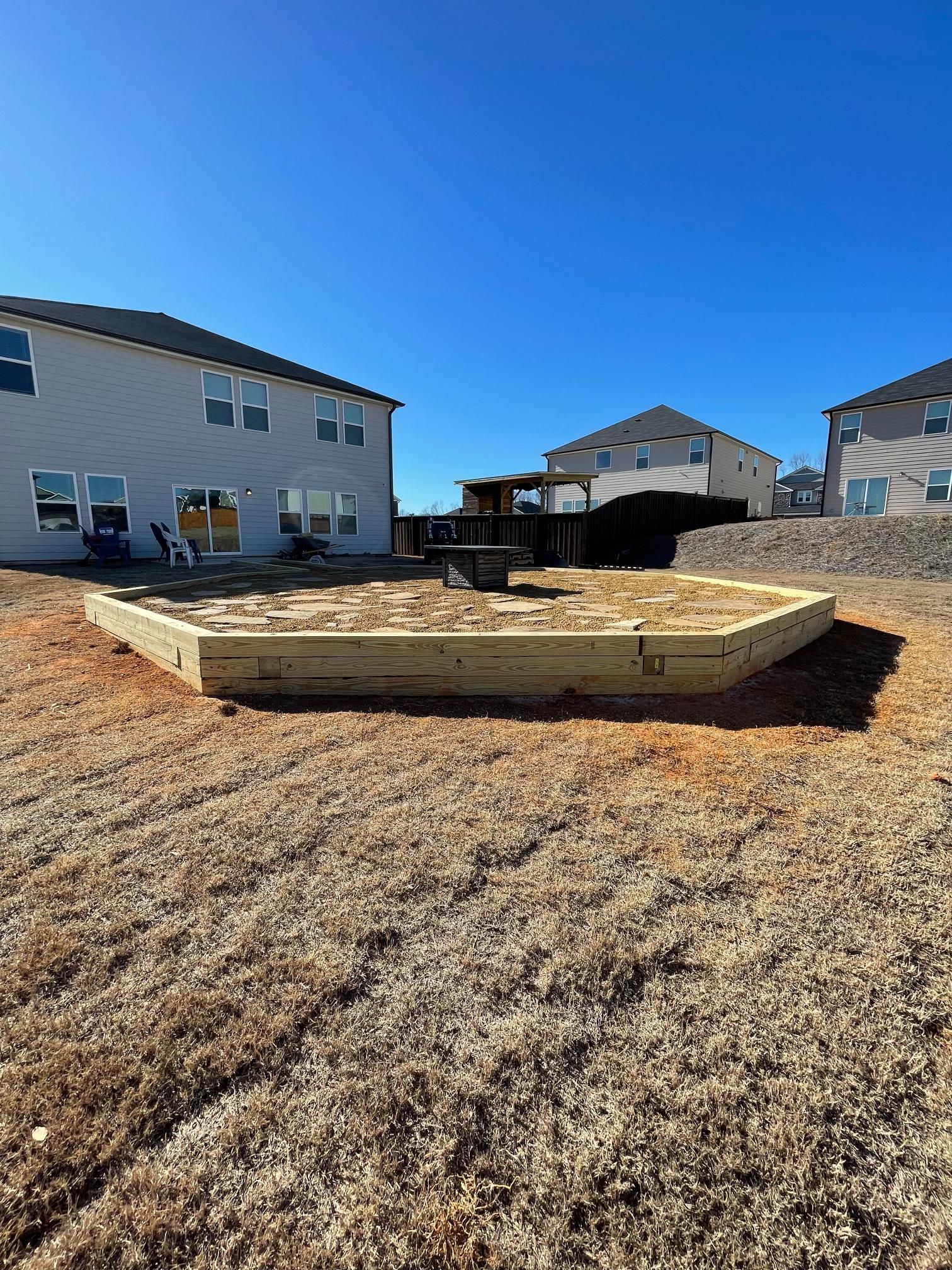 A wooden deck is being built in the backyard of a house.