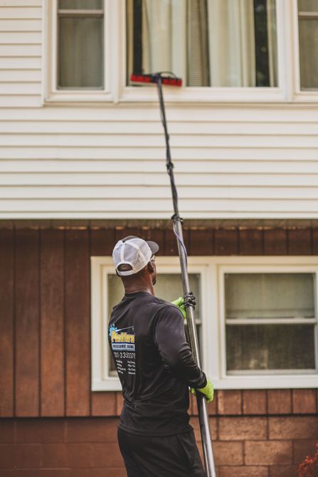 a man is cleaning a window with a pole that has the number 1337 on it