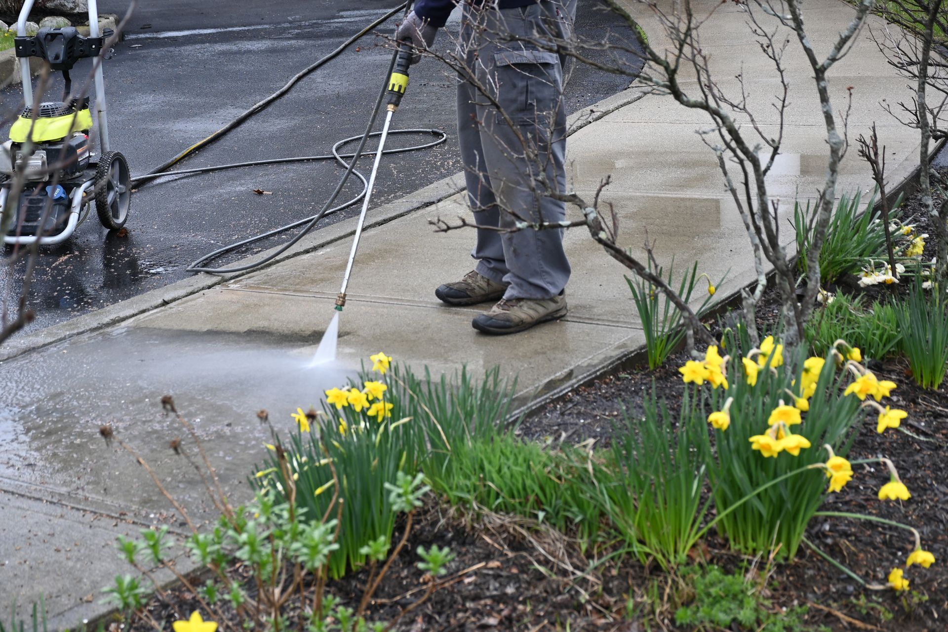 a person is using a high pressure washer to clean a sidewalk