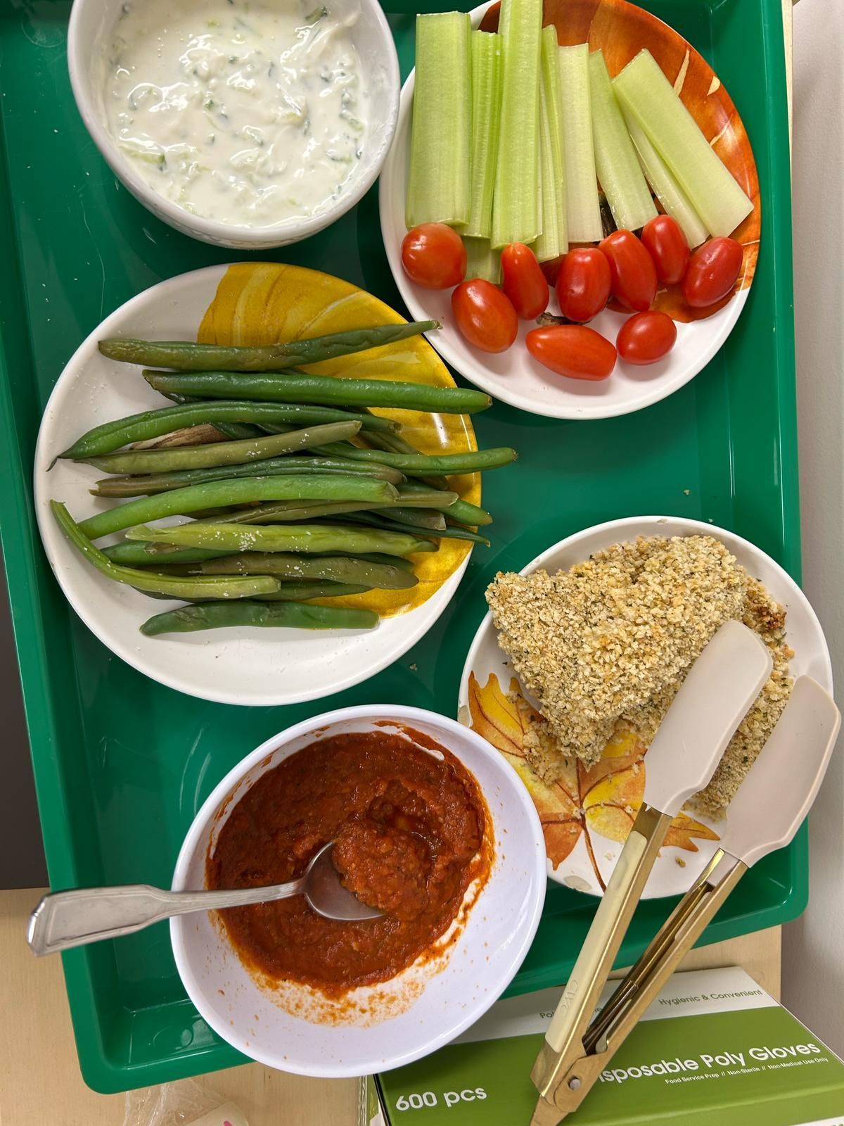 A tray of food including green beans tomatoes and celery