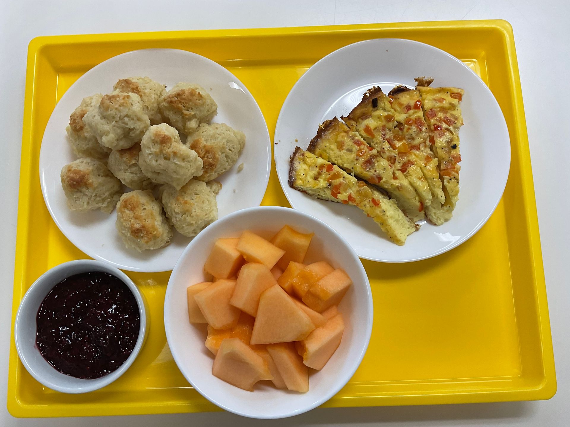 A yellow tray with plates of food and fruit on it