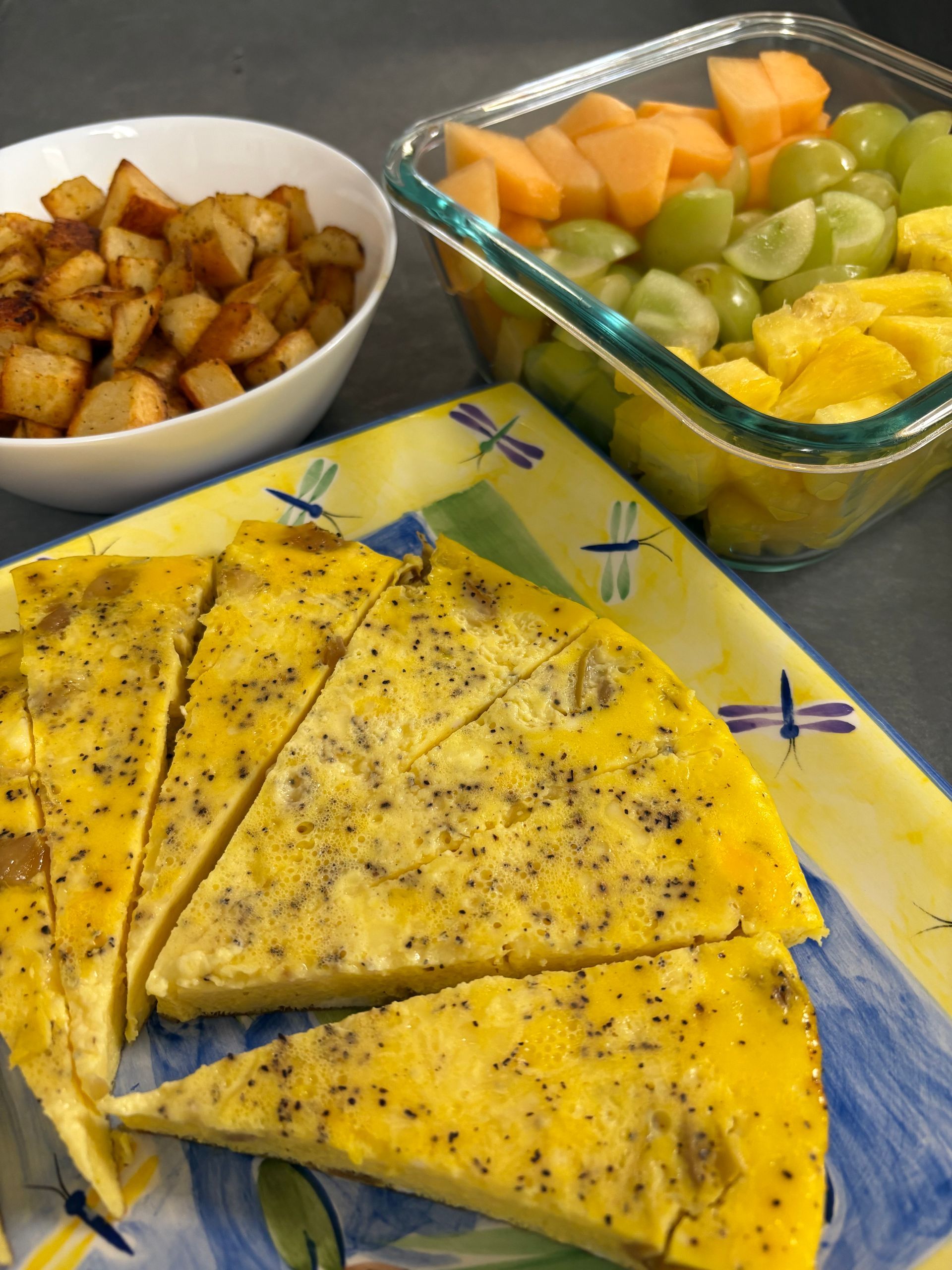 A plate of food with a bowl of potatoes and a bowl of fruit