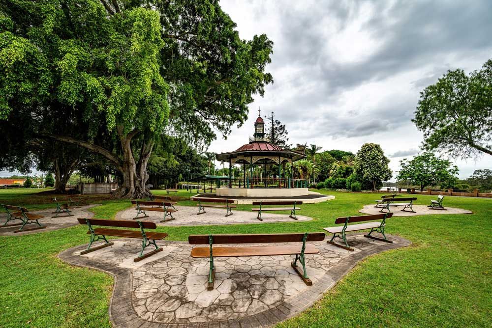 A Group Of Benches In A Park With A Gazebo In The Background — Wide Bay Hydraulics in Maryborough, QLD
