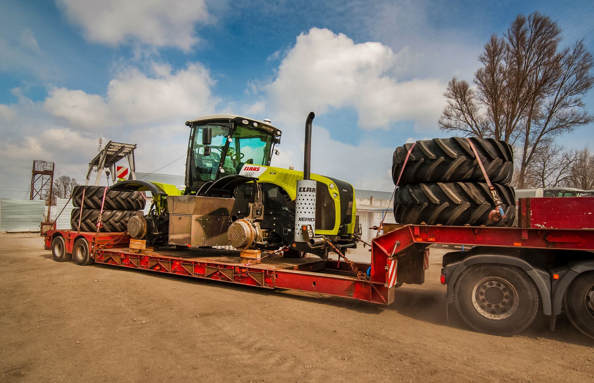 Heavy machinery on a flatbed truck, being transported on a road.