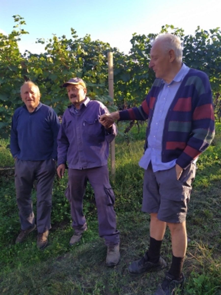 Tre uomini sono in piedi in un campo e parlano tra loro