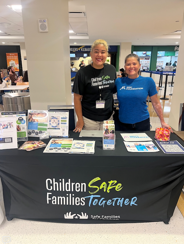 Two women stand behind a table with a 