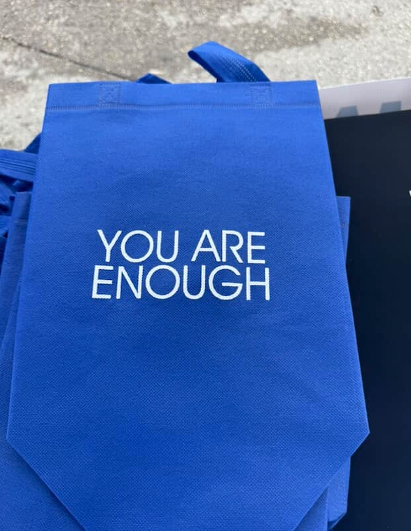 Blue tote bag with white text 