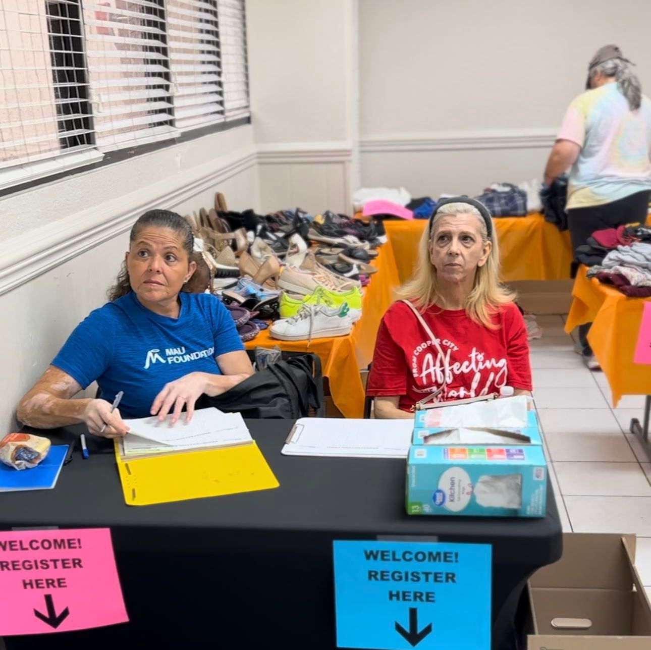 Two women sit at a table labeled 