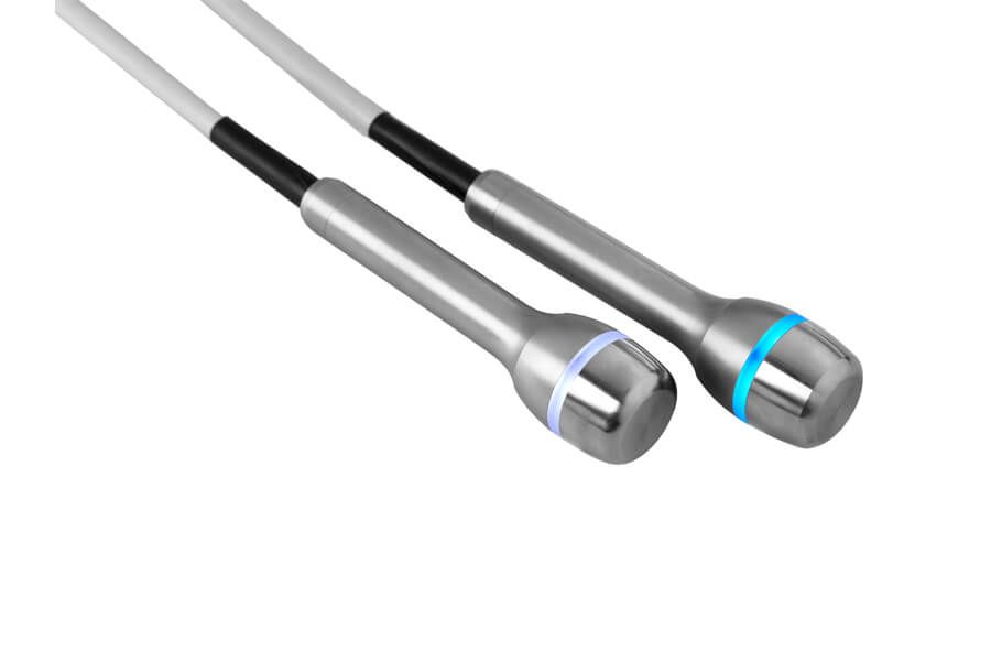 Zwei silberne Sonden mit abgerundeten Enden und farbigen Leuchtringen, verbunden mit weißen Kabeln, abgewinkelt auf weißem Hintergrund.