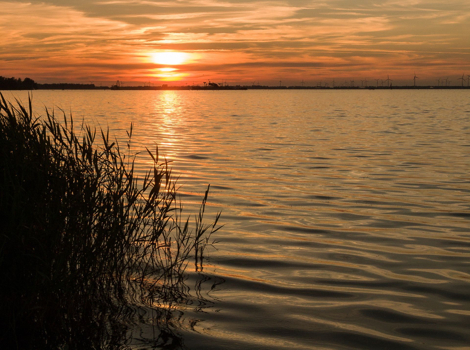 De zon gaat onder boven een groot wateroppervlak