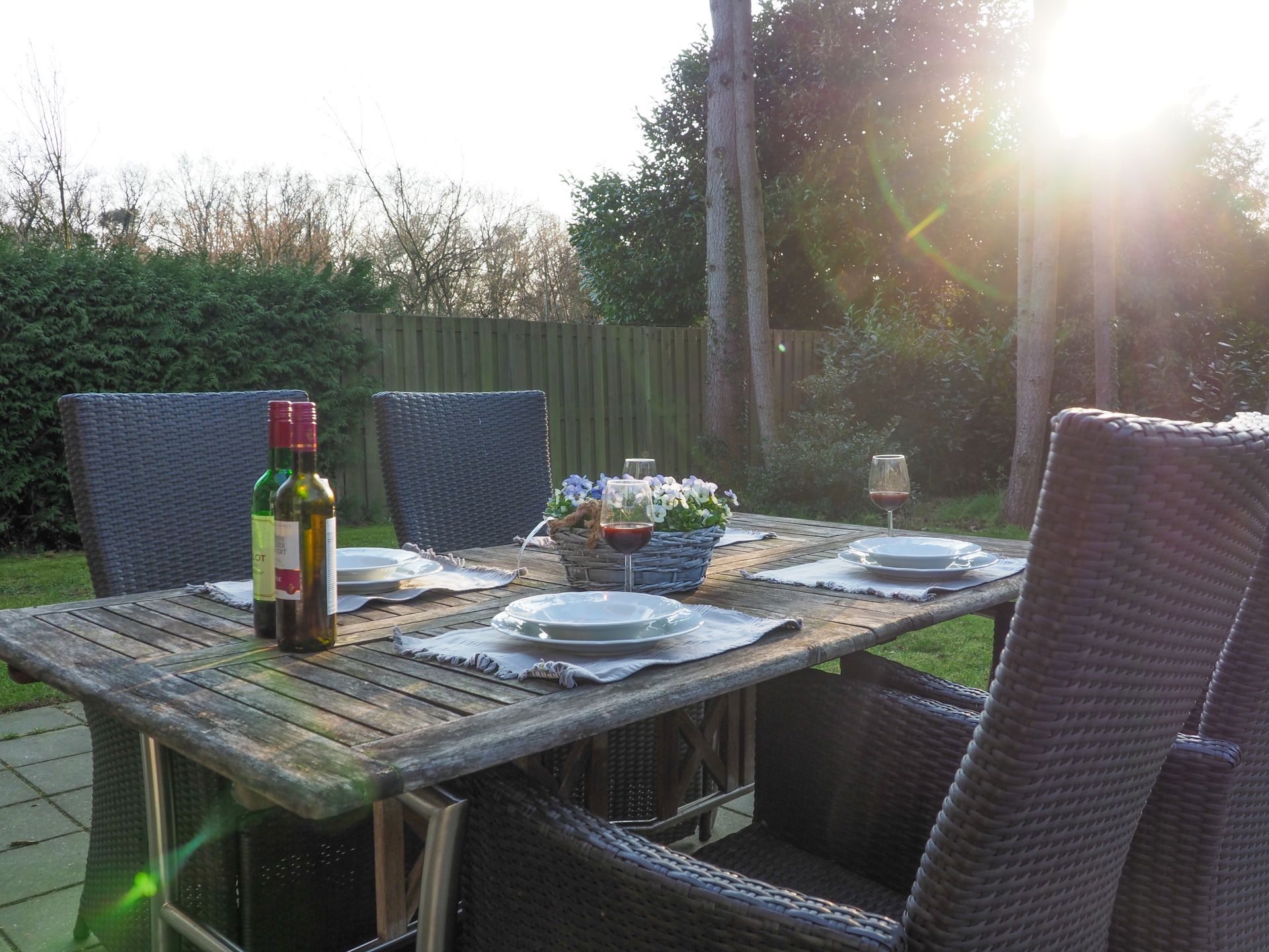 Een tafel met borden en een fles wijn erop