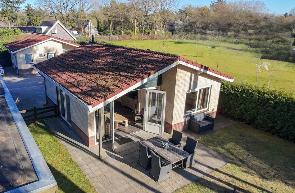 Een luchtfoto van een huis met een tafel en stoelen op het terras.