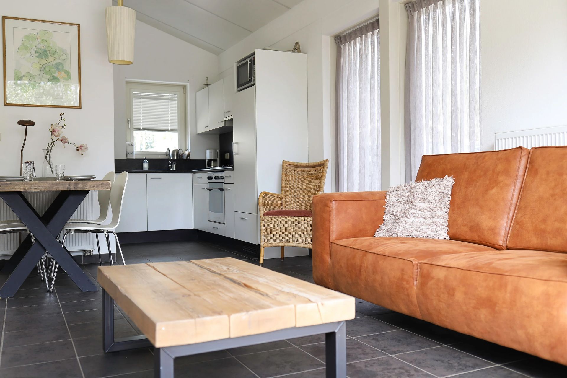 Een woonkamer met een bruine bank en een houten salontafel.