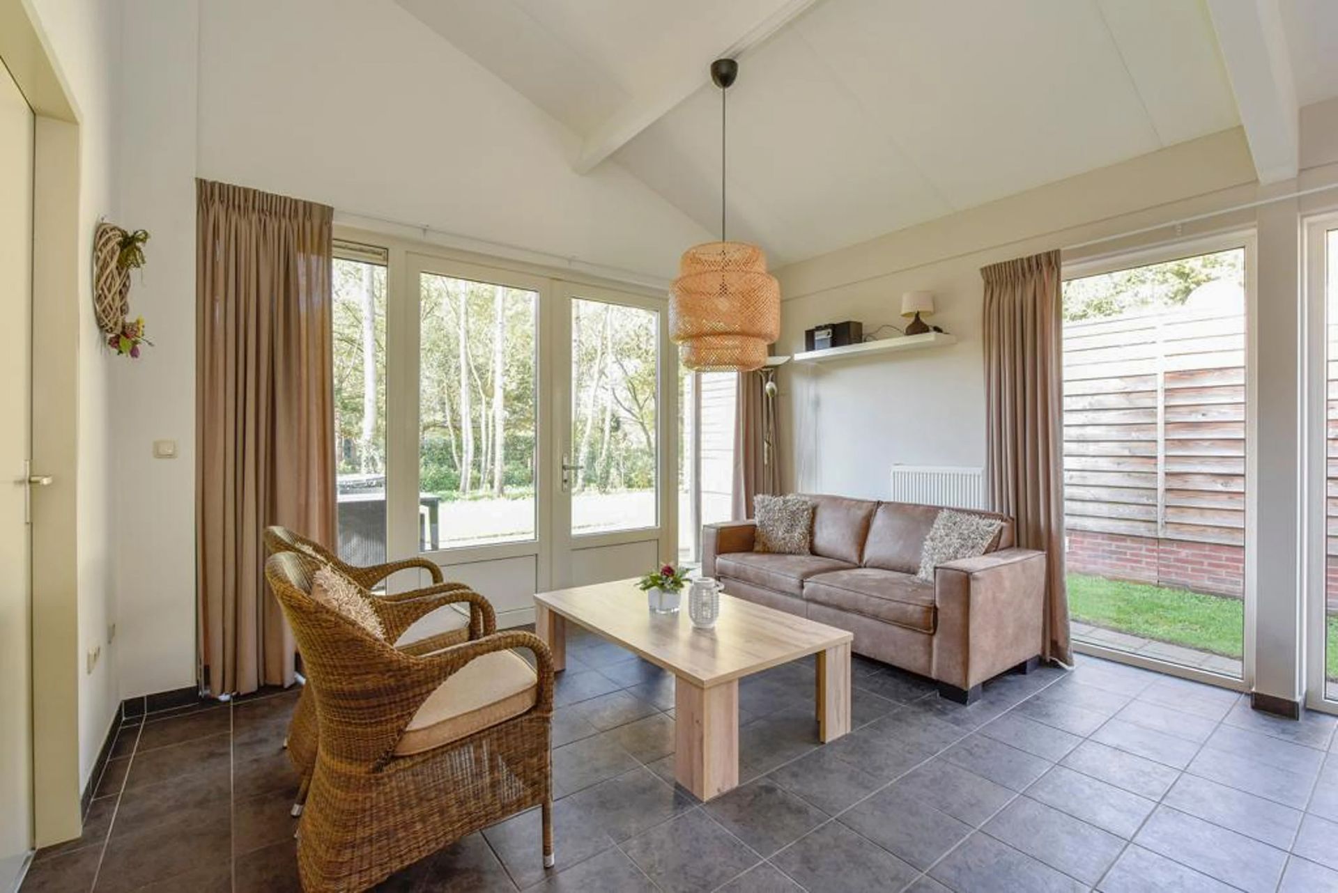 Een woonkamer met een bank, stoelen en een salontafel.