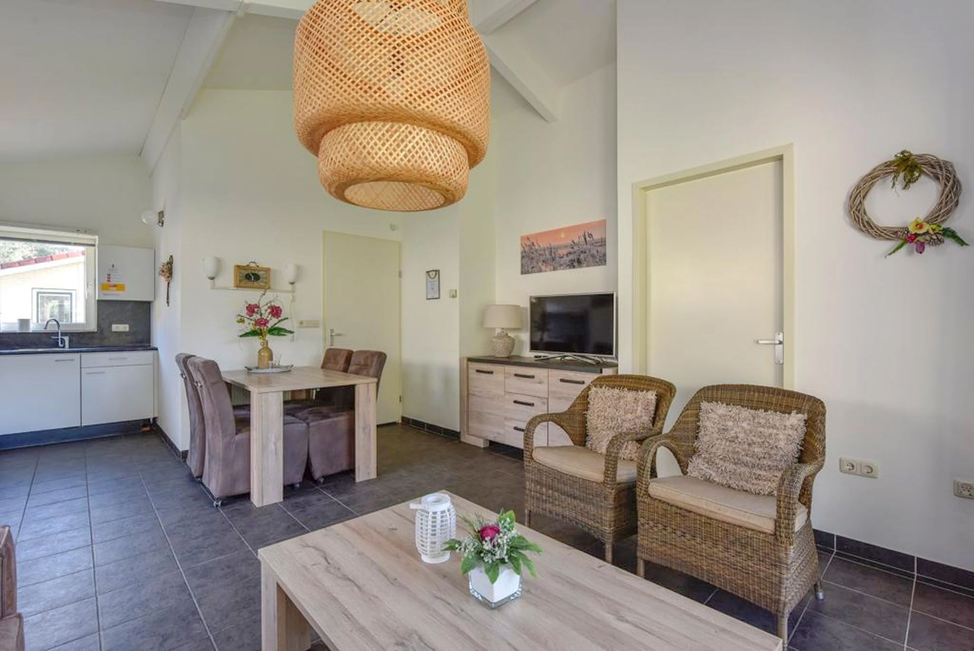 Een woonkamer met een tafel, stoelen en een televisie.