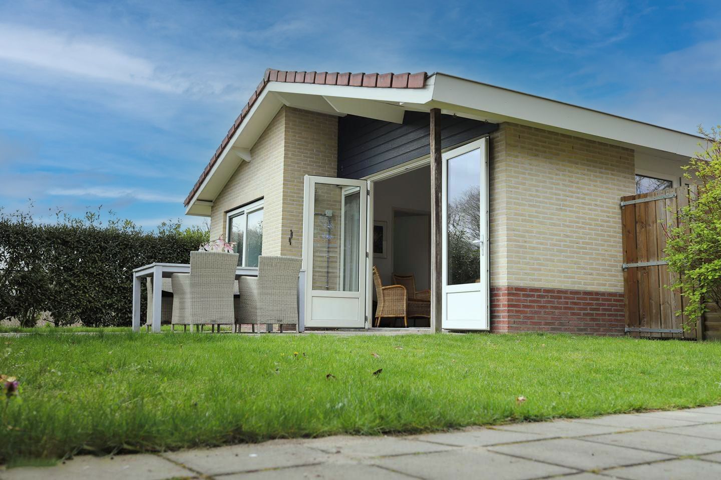 Een klein huis met een groot gazon ervoor.