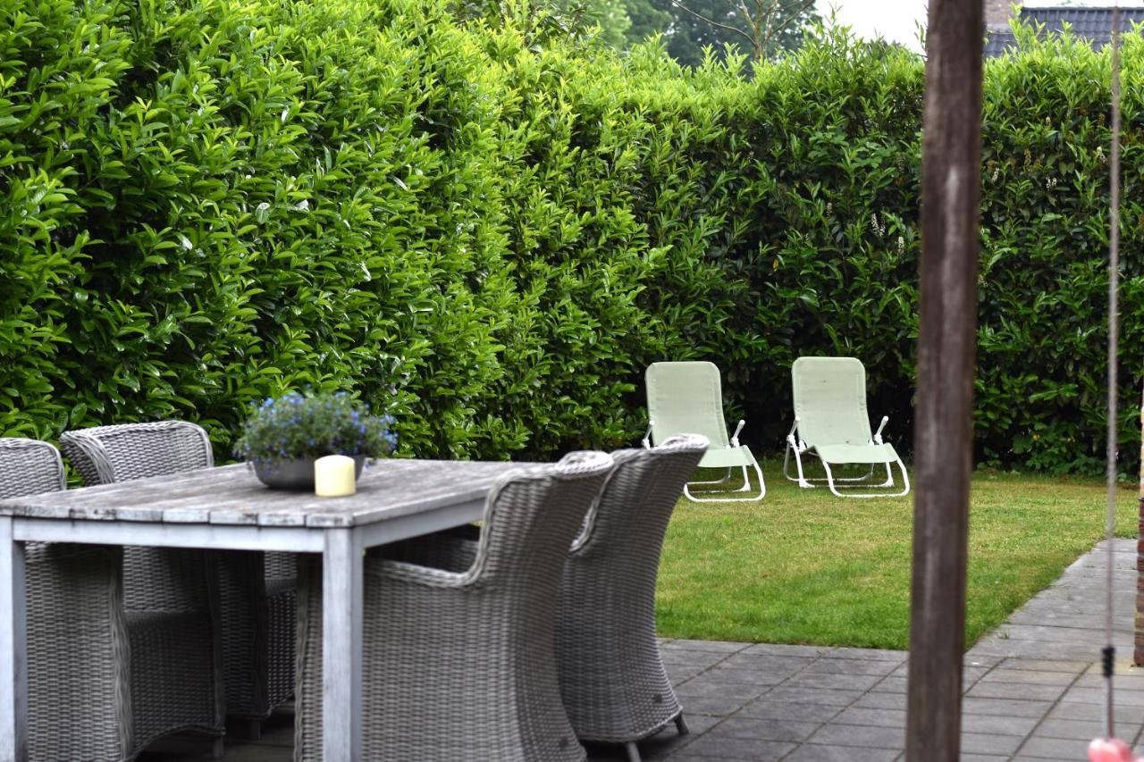 Een terras met een tafel en stoelen in de achtertuin