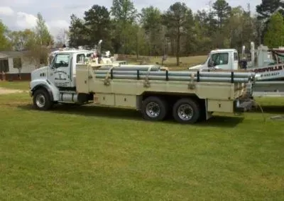 A large truck is parked in a grassy field.
