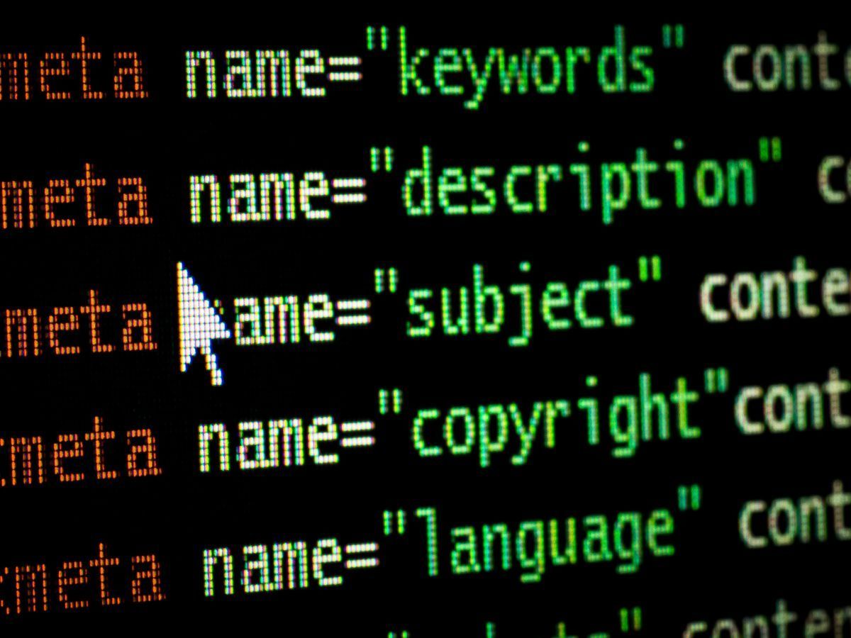 Lignes de code affichant des balises méta HTML,des mots-clés, une description, un sujet, sur un écran sombre.