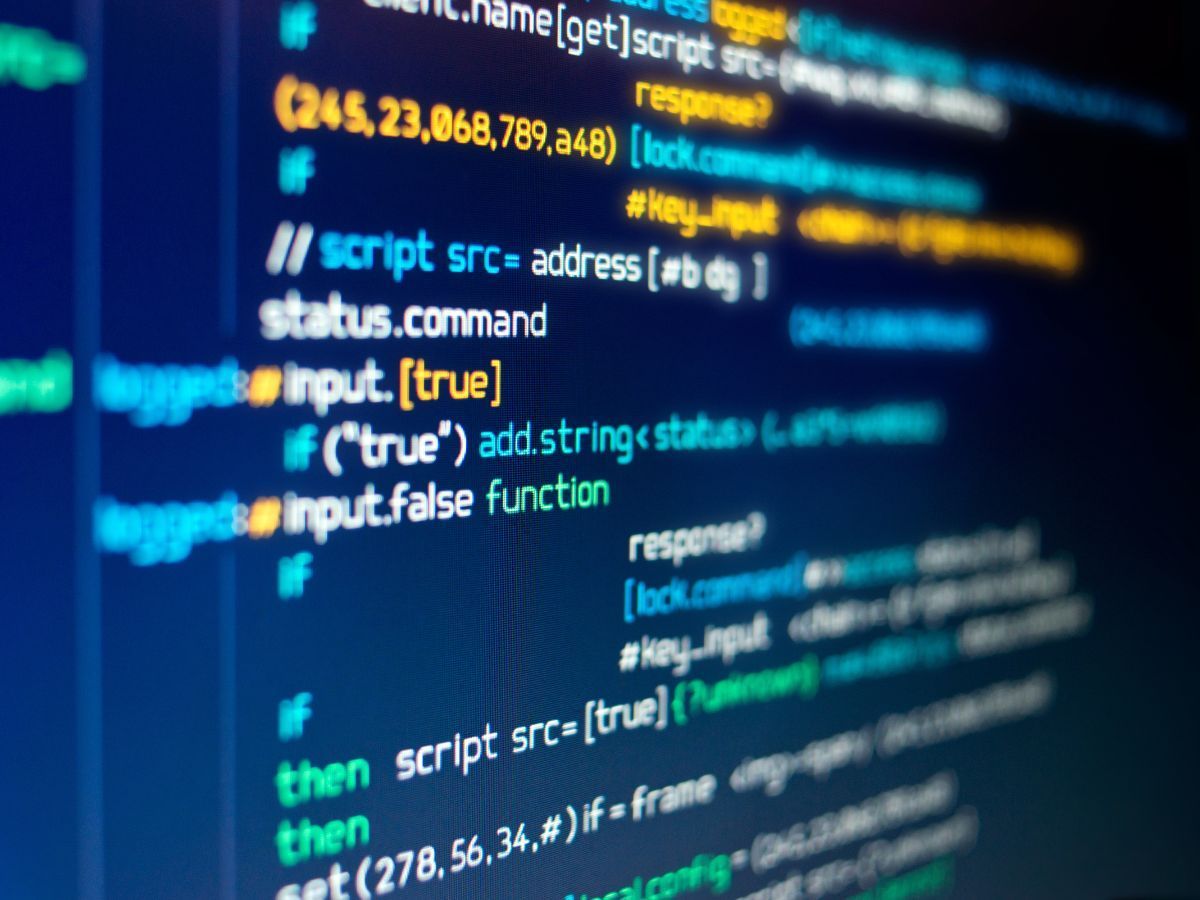 Lignes de code informatique de différentes couleurs sur un fond bleu foncé.